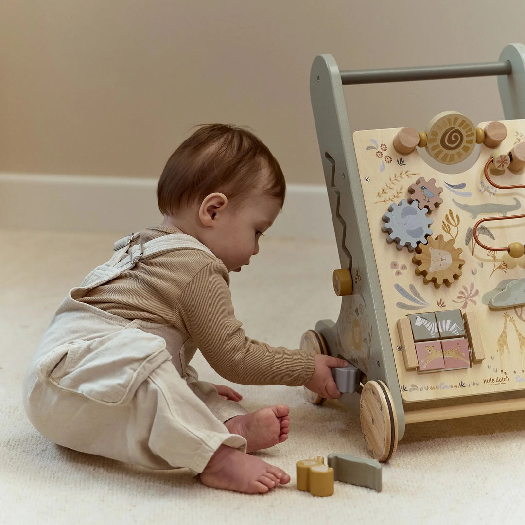 Kind speelt met een houten blok bij de Little Dutch Safari Friends loopwagen