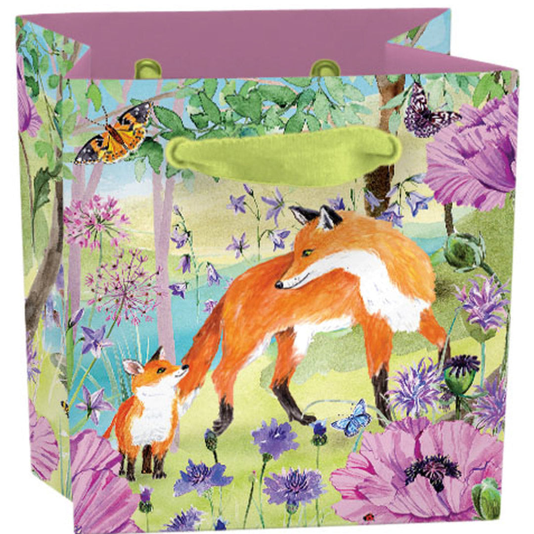Sac cadeau Roger La Borde Sunny and Wild, Mini, avec un renard et un renardeau parmi des fleurs, des feuilles et des papillons.