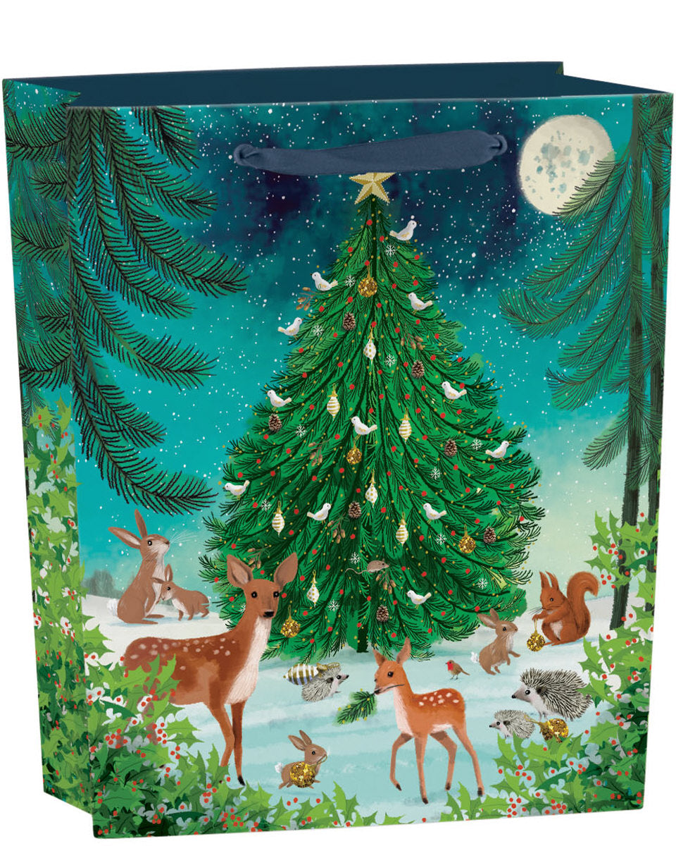 Sac cadeau Roger La Borde Heart of the Forest, Medium, avec un sapin de Noël et des animaux de la forêt sous un ciel éclairé par la lune.