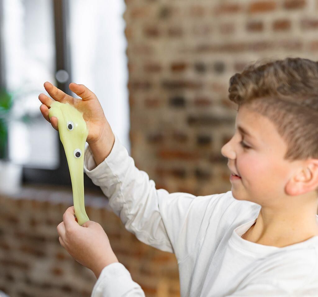 Kind rekt lichtgroen slijm uit bij de Moses PhänoMINT Glow-experimenten.
