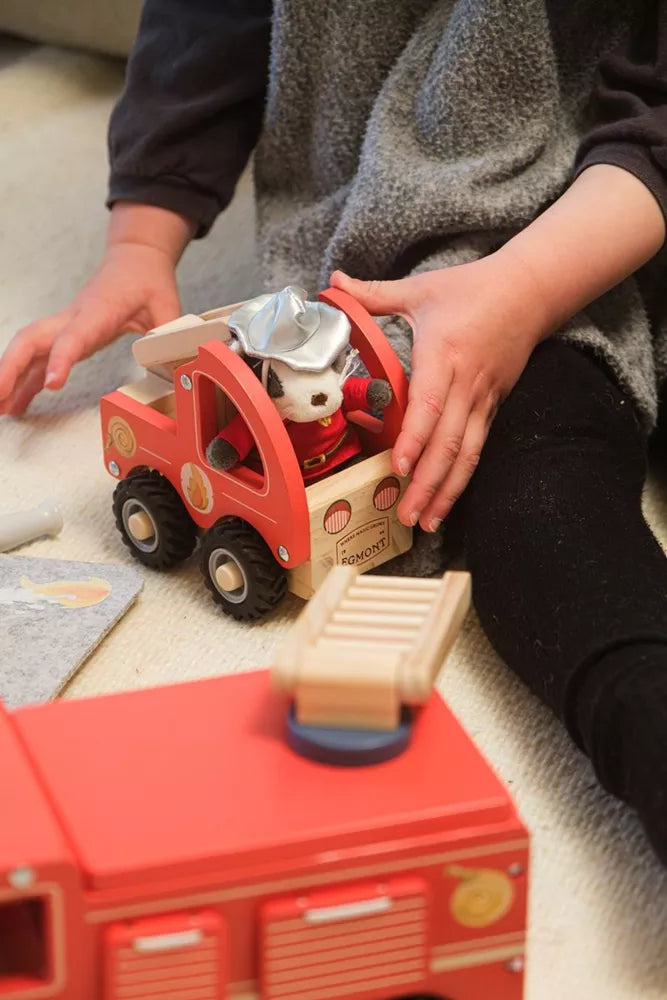 Kind spielt mit dem Egmont Toys Feuerwehrwagen und der Feuerwehrkatze