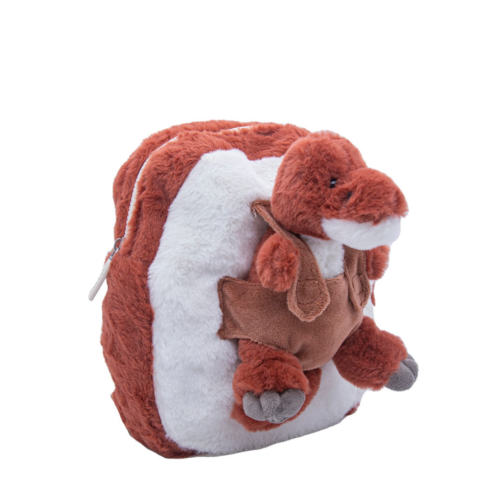 Side view of the red-brown dinosaur backpack with small plush toy