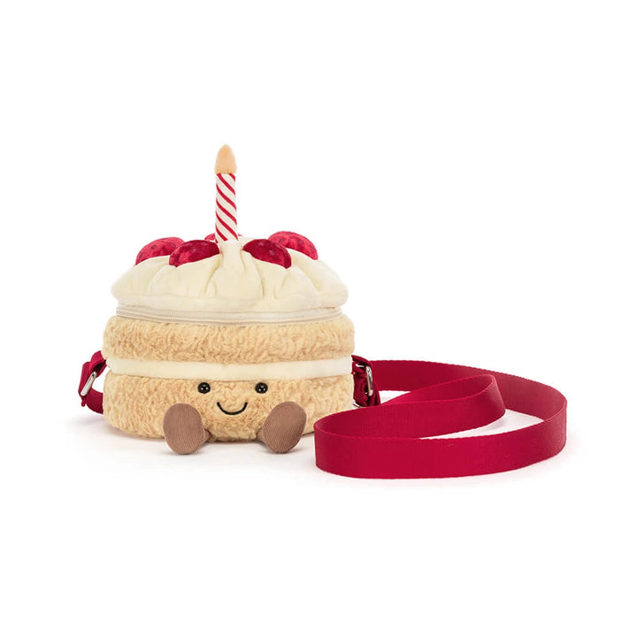 Jellycat Amuseables Birthday Cake Bag met glimlach en rode draagriem, schuin vooraanzicht