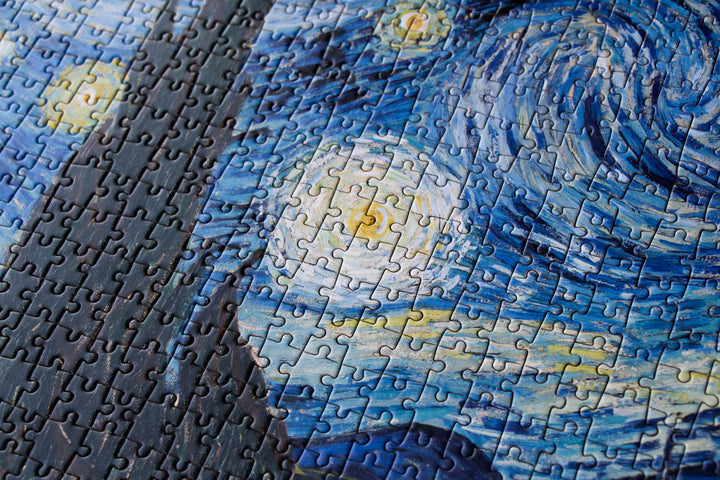 Close-up of puzzle pieces in the night sky of The Starry Night
