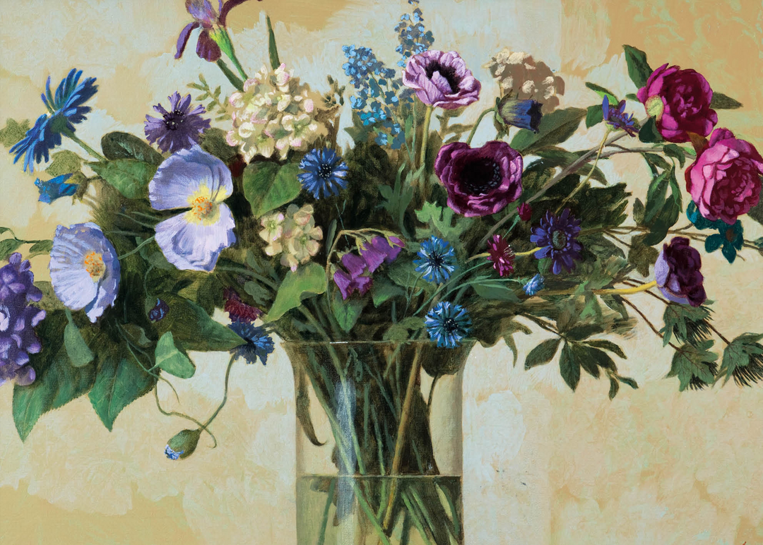 Des fleurs bleues et violettes sont disposées dans un vase en verre.