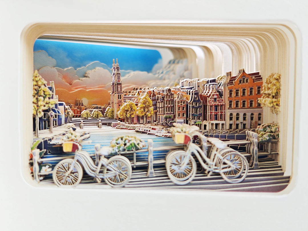 Fietsen, grachtenhuizen en de Westerkerk in de uitgesneden papierlagen