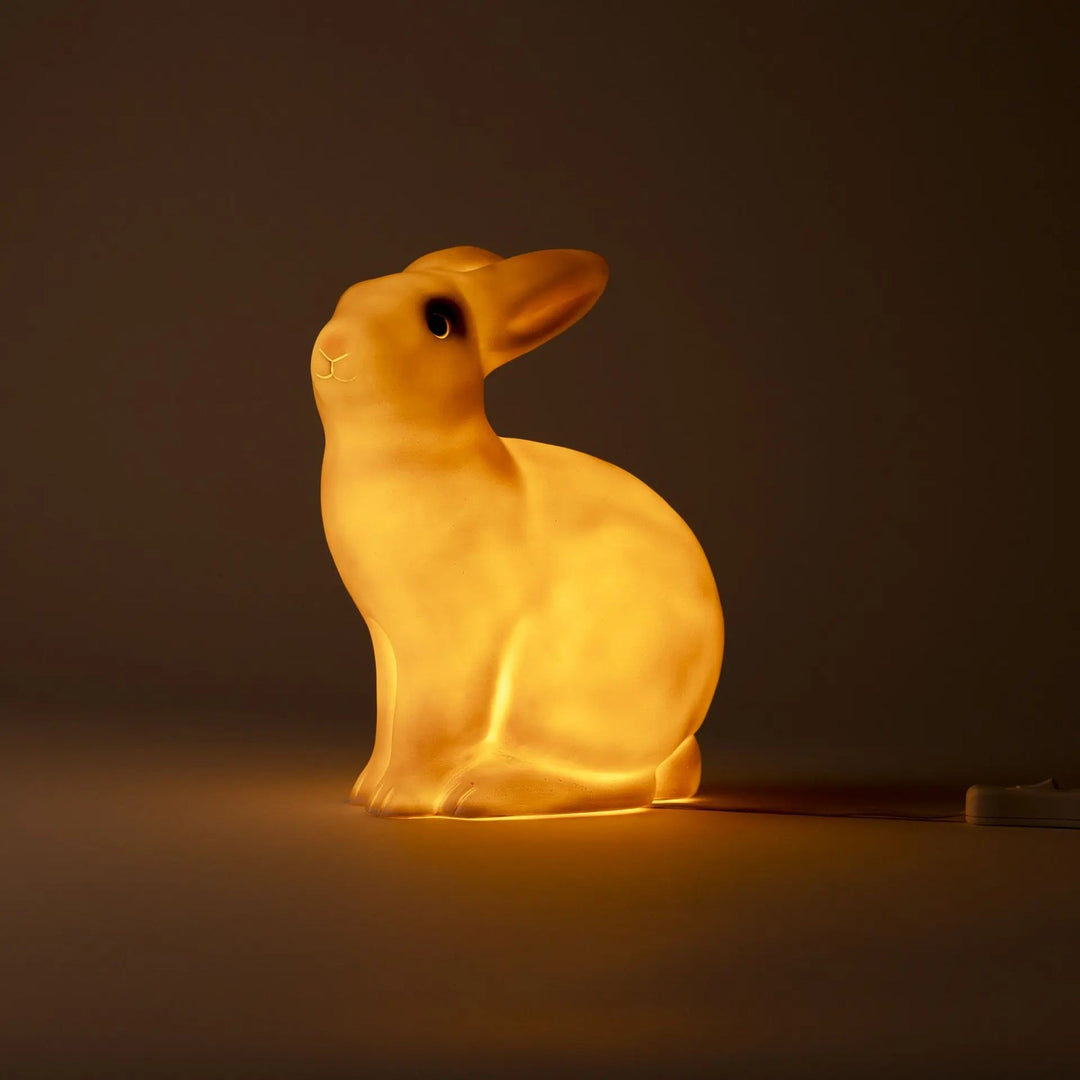 Brandende witte Egmont Toys konijnenlamp van opzij in het donker