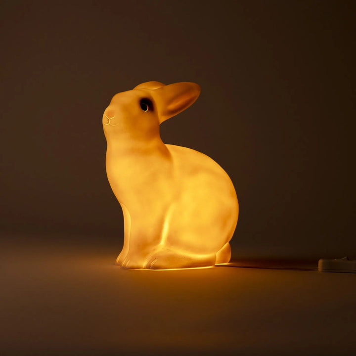 Brandende witte Egmont Toys konijnenlamp van opzij in het donker