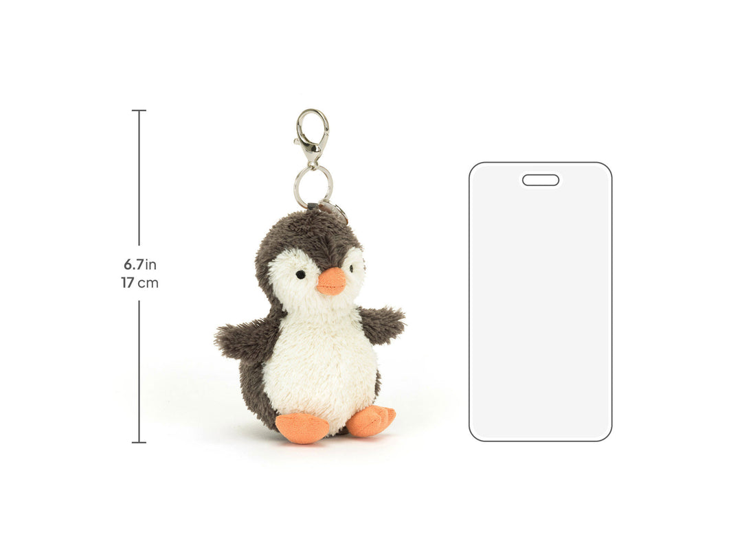 Jellycat Peanut Penguin Bag Charm naast een telefoonsilhouet, met totale hoogtemaat van 17 cm