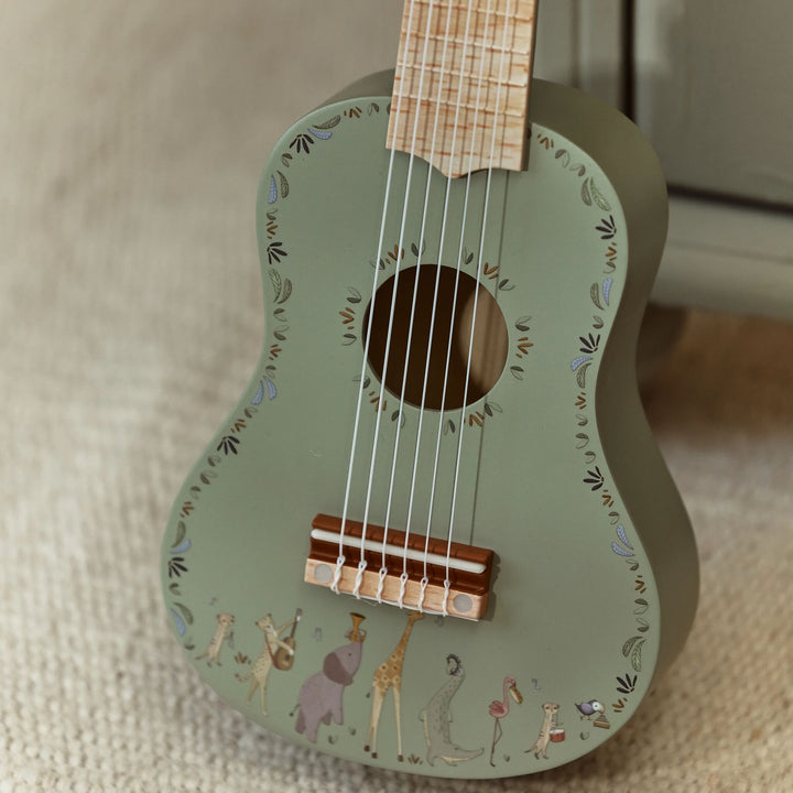 Close-up van klankkast en zes snaren van de groene Little Dutch Safari Friends gitaar