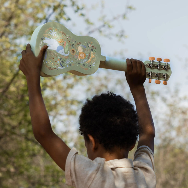Kind houdt de groene Little Dutch Safari Friends gitaar omhoog