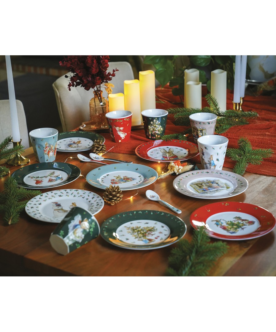Rode Peter Rabbit kerstlepel tussen borden, bekers en kaarsen op een gedekte tafel