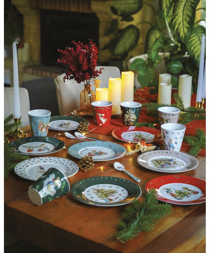Rode Peter Rabbit kerstbeker met ander servies en kaarsen op een kersttafel