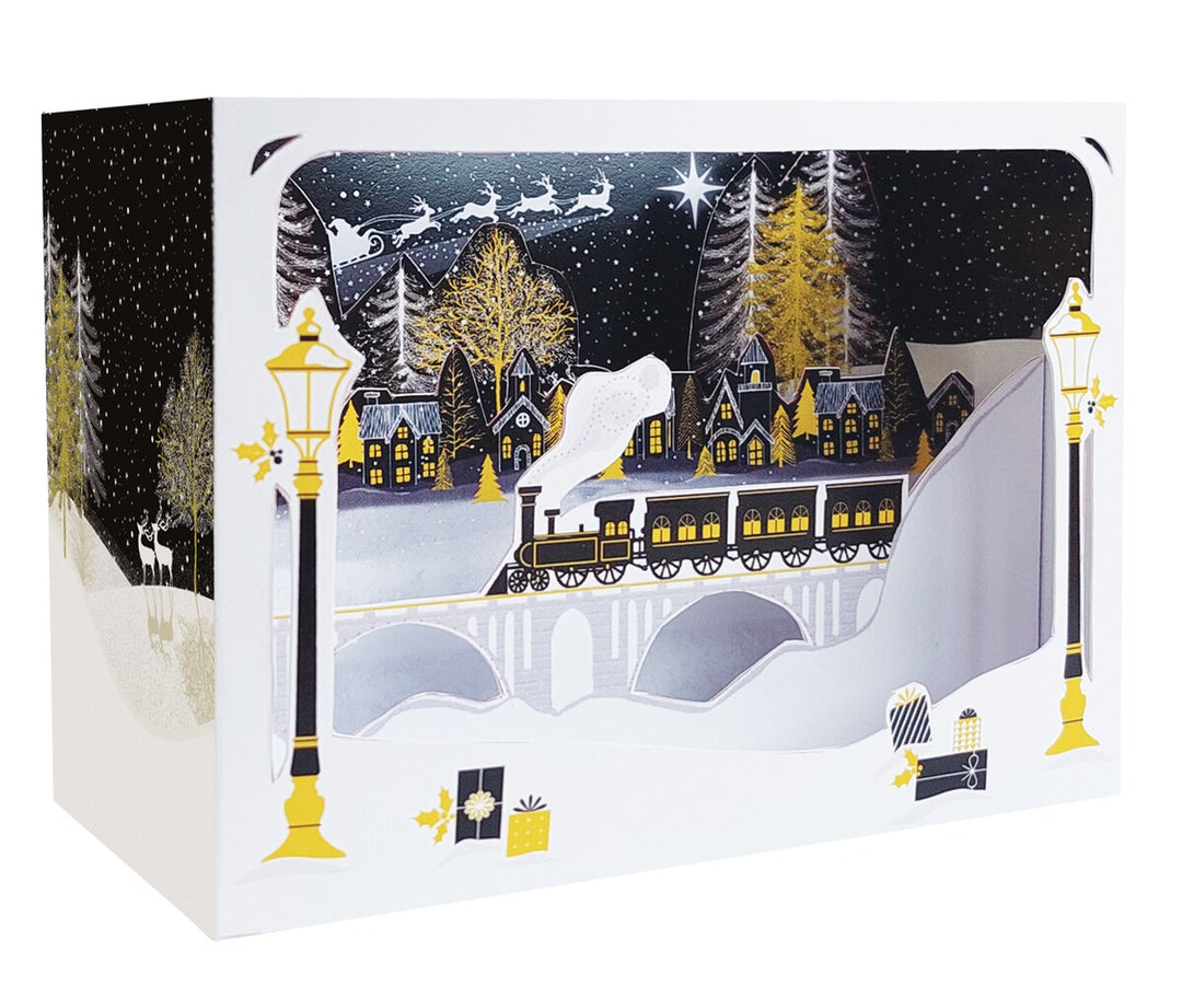 Carte de Noël 3D Pictura avec train illuminé sur un pont et traîneau du Père Noël dans le ciel.