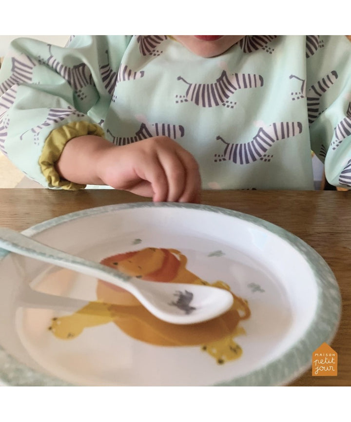 Petit Jour Savanne-lepel met zebra op een bord bij een kind met Savanne-slab